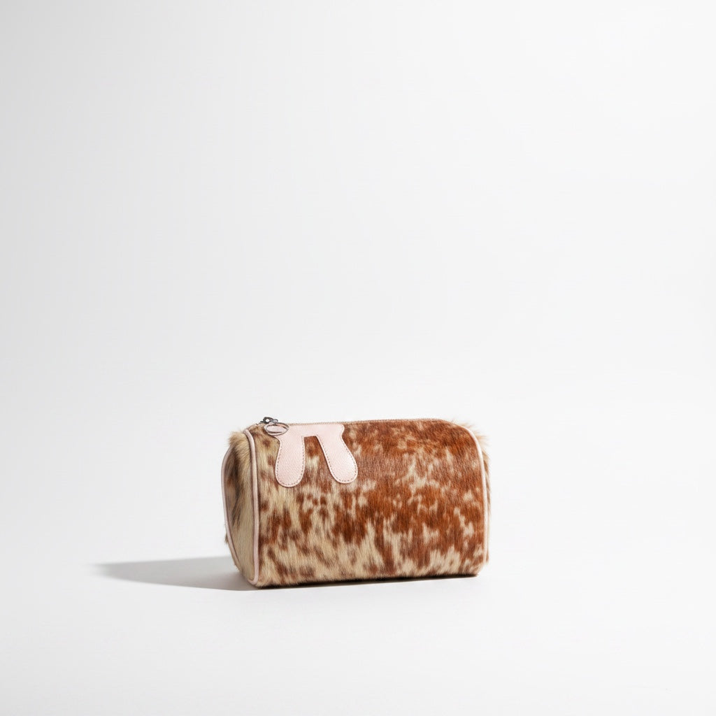 Design Girls World pink and brown cowhide fur cylinder cosmetic bag with pink leather trim and bunny ear detail.
