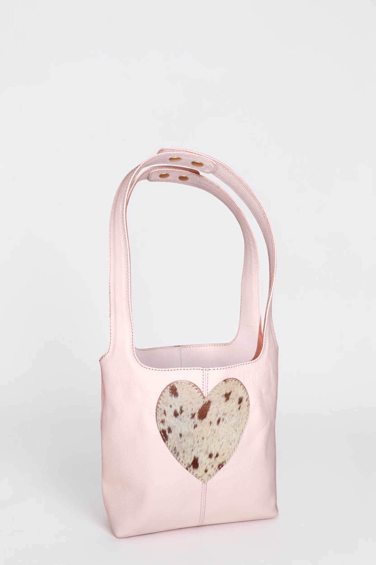 Design Girls World pink leather mini tote bag with a cowhide heart cutout detail and top handles.